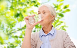 example of a senior woman caring for her health by drinking water